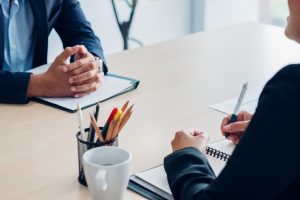 An interviewer utilizes behavioral interview questions to evaluate an aspiring applicant.