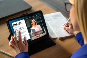 A recruiter reviewing an applicant’s LinkedIn profile on a tablet, representing attracting passive candidates.