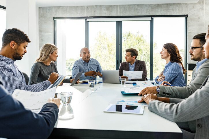 A group of employees sitting in a circle during a team discussion, representing retaining top talent strategies in the workplace.