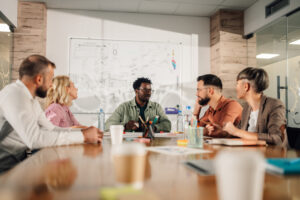 A diverse group of professionals engaged in a collaborative meeting to implement strategic solutions for reducing employee turnover within a modern office setting.