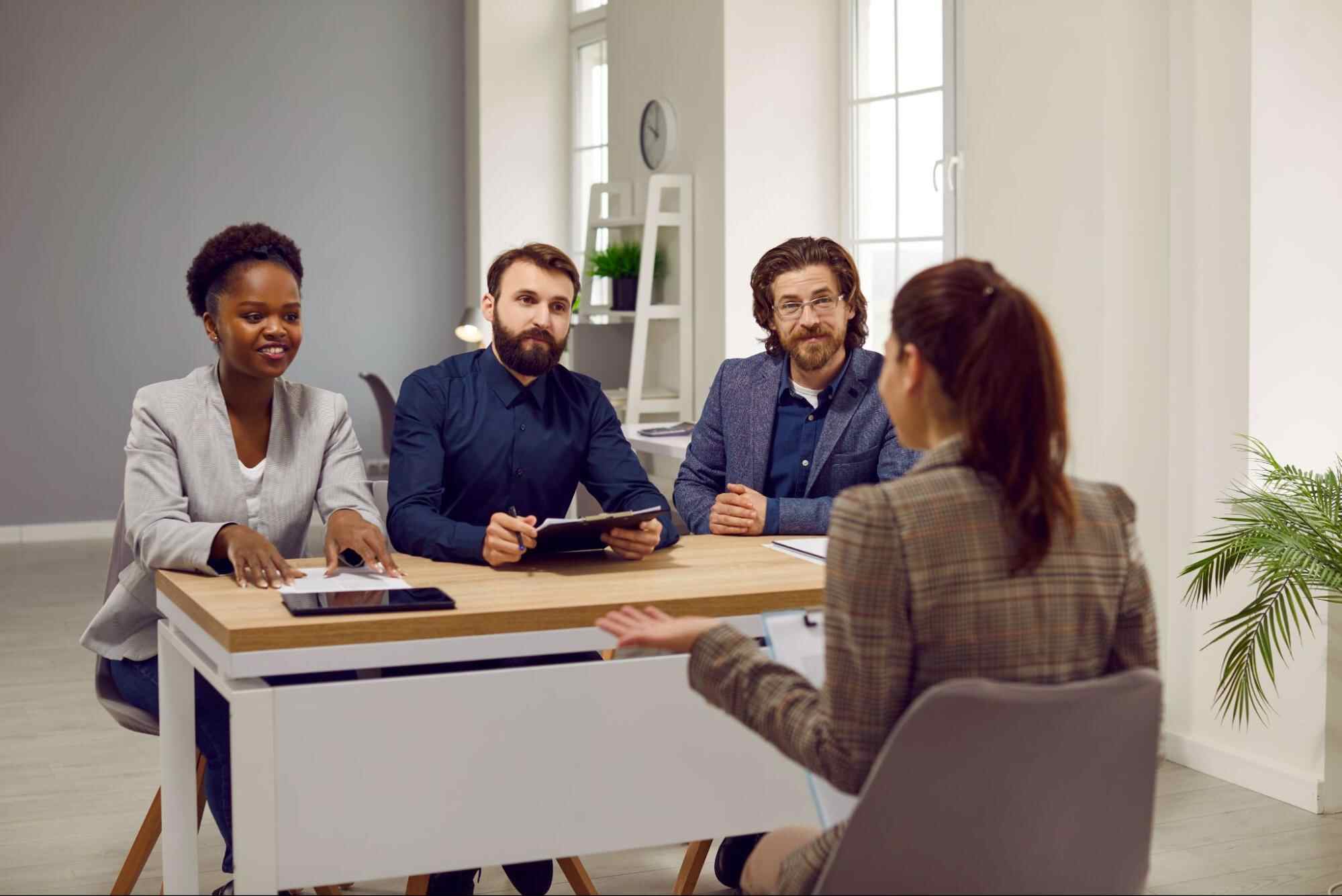 Hiring managers interviewing a job candidate in a professional office setting illustrating what a candidate profile is and how businesses evaluate skills, experience, and workplace fit during recruitment.