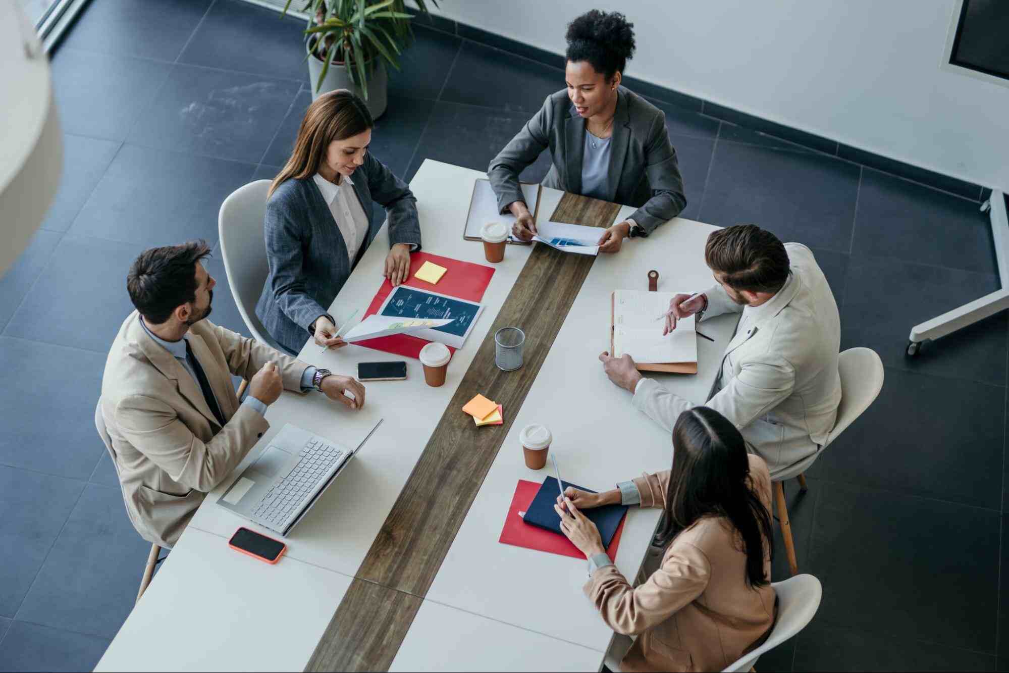 Business professionals collaborating in a boardroom meeting, reviewing staffing forecasts and workforce planning strategies to support hiring decisions, talent acquisition, and long-term business growth.